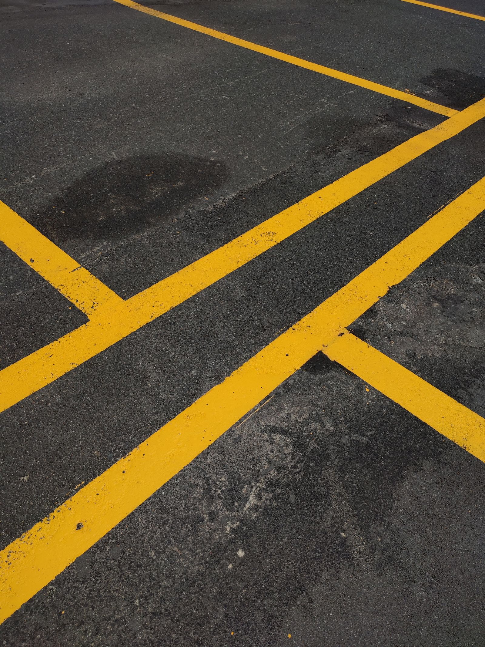 Crisp freshly painted yellow aisle lines on dark pavement